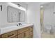 Well-lit bathroom with a wood vanity, modern countertop, a framed mirror, and an adjacent walk-in shower at 1851 Oleander Ct, Charleston, SC 29414