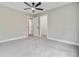 A cozy bedroom with neutral tones, plush carpet, a ceiling fan, and an open doorway to an adjacent room at 1851 Oleander Ct, Charleston, SC 29414