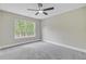 A bright bedroom with neutral walls, plush carpet, a ceiling fan, and a window providing natural light at 1851 Oleander Ct, Charleston, SC 29414