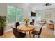 Bright dining area featuring a round wood table, leather chairs, large windows, and hardwood flooring at 1851 Oleander Ct, Charleston, SC 29414