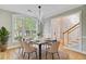 Elegant dining room with a modern light fixture, large window, and access to the home's entryway and staircase at 1851 Oleander Ct, Charleston, SC 29414