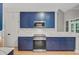 The kitchen features blue cabinets, stainless steel appliances, and stone countertops at 1851 Oleander Ct, Charleston, SC 29414