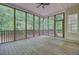 Screened-in porch with wood flooring, offering an outdoor living space surrounded by trees at 1851 Oleander Ct, Charleston, SC 29414