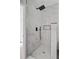 A modern shower featuring marble-like tile, sleek black fixtures, and a recessed shelf for a spa-like experience at 1851 Oleander Ct, Charleston, SC 29414
