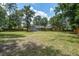 Lush backyard showcasing mature trees, a well-manicured lawn, and a charming home with a screened porch for relaxation at 19 Milano Ct, Hanahan, SC 29410