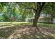 Picturesque backyard featuring lush lawn, mature trees, and home with a screened-in porch, creating a serene outdoor retreat at 19 Milano Ct, Hanahan, SC 29410