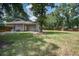 Spacious backyard with lush lawn, mature trees, and home featuring neutral siding and a grill, ideal for outdoor enjoyment at 19 Milano Ct, Hanahan, SC 29410