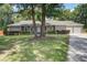 Charming single-story home with a well-manicured lawn, mature trees, and attached two-car garage at 19 Milano Ct, Hanahan, SC 29410