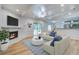 Bright living room with a white-painted brick fireplace, wood floors, and an open layout at 19 Milano Ct, Hanahan, SC 29410