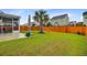 Beautifully landscaped backyard featuring a well-maintained lawn, mature palm tree, and inviting screened porch at 192 Weeping Cypress Dr, Moncks Corner, SC 29461