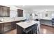 Modern kitchen featuring an island with a white countertop and black stools, opening to the bright and airy living room at 192 Weeping Cypress Dr, Moncks Corner, SC 29461