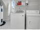 Efficient laundry room featuring modern washer and dryer units with storage shelving and a window at 200 Oak Point Landing Dr, Mount Pleasant, SC 29464