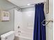 Clean bathroom with a shower-tub combo, blue shower curtain, and neutral wall paint at 201 W Arctic Ave # 406, Folly Beach, SC 29439