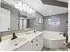 Bright bathroom features double vanity, soaking tub, and beach-themed decor at 201 W Arctic Ave # 406, Folly Beach, SC 29439