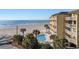 Beautiful ocean view, pool surrounded by palm trees at an oceanfront condo offering a relaxing escape at 201 W Arctic Ave # 406, Folly Beach, SC 29439