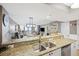 Kitchen with granite counters overlooking dining and living area and ocean views at 201 W Arctic Ave # 406, Folly Beach, SC 29439