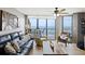 Bright living room with comfortable seating, ocean views, and access to the balcony at 201 W Arctic Ave # 406, Folly Beach, SC 29439