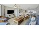 Open concept living room with comfortable seating, ceiling fan, and easy access to dining and kitchen at 201 W Arctic Ave # 406, Folly Beach, SC 29439