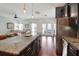 Open concept kitchen with island seating, flowing into a bright living area with access to outdoor space at 2025 Maybelles Ln, Charleston, SC 29414