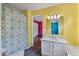 Bright yellow bathroom featuring a marble vanity and colorful shower curtain at 206 Hawkridge Pl, Goose Creek, SC 29445