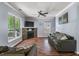 Cozy living room with hardwood floors, stone fireplace, ceiling fan, and large window providing natural light at 206 Hawkridge Pl, Goose Creek, SC 29445