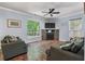 Cozy living room with a stone fireplace, hardwood floors, and large windows, perfect for relaxation and entertaining at 206 Hawkridge Pl, Goose Creek, SC 29445