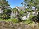 Home backyard featuring lush landscaping, a deck, screened-in porch and well-maintained lawn at 2141 Sandy Point Ln, Mount Pleasant, SC 29466