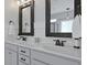 Bathroom featuring double sink vanity with granite counters, dark wood framed mirrors, and wainscoting at 2141 Sandy Point Ln, Mount Pleasant, SC 29466