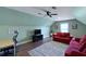 Spacious bonus room with a red sofa, ceiling fan, and entertainment center, perfect for relaxing at 2141 Sandy Point Ln, Mount Pleasant, SC 29466