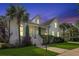 Exterior dusk shot of beautiful two-story home with front porch and manicured lawn at 2141 Sandy Point Ln, Mount Pleasant, SC 29466