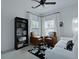Cozy living room featuring leather chairs, modern bookshelf, and a stylish black and white area rug at 2141 Sandy Point Ln, Mount Pleasant, SC 29466