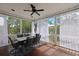 Screened-in back porch with dining table, chairs, and ceiling fan, great for enjoying the outdoors at 2141 Sandy Point Ln, Mount Pleasant, SC 29466