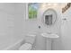 Cozy bathroom with a pedestal sink, a round mirror, and natural lighting at 2184 Tall Grass Cir, Mount Pleasant, SC 29466