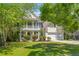 Charming two-story home boasts a welcoming front porch and a well-manicured lawn with mature trees at 2184 Tall Grass Cir, Mount Pleasant, SC 29466
