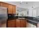 Modern kitchen with dark countertops, wood cabinets, stainless appliances and view of the living room at 2184 Tall Grass Cir, Mount Pleasant, SC 29466