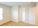 A bright bedroom features neutral walls, carpet, two white doors, and a window at 241 Wathen Dr, Goose Creek, SC 29445