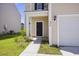 Home exterior featuring a charming front door, freshly landscaped yard, and an attached garage at 278 Catawba Branch Way, Moncks Corner, SC 29461