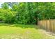 A fenced backyard with lush lawn and mature trees providing privacy and shade at 286 Chemistry Cir, Ladson, SC 29456