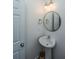 Neat half bathroom featuring a pedestal sink, round mirror, and modern lighting at 286 Chemistry Cir, Ladson, SC 29456
