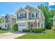 Charming two-story home featuring manicured lawn, gray siding and an inviting front porch with a US flag at 286 Chemistry Cir, Ladson, SC 29456