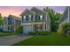 Charming two-story home featuring manicured lawn, gray siding and an inviting front porch with a US flag at 286 Chemistry Cir, Ladson, SC 29456