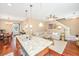 Open-concept living space with kitchen island flowing into the dining and living areas with hardwood floors at 286 Chemistry Cir, Ladson, SC 29456