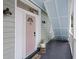 Charming entrance featuring a pink front door, painted porch ceiling and stylish outdoor lighting at 29 Bogard St, Charleston, SC 29403