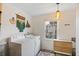 Well-lit laundry area with side-by-side machines, decor, and a folding table near a window at 29 Bogard St, Charleston, SC 29403