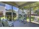 This screened-in porch offers a relaxing outdoor space with rocking chairs and view of the well-maintained backyard at 30 Regency Oaks Dr, Summerville, SC 29485