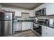 Well-lit kitchen with stainless steel appliances, dark countertops, and white cabinetry at 306 Crestview Dr # C, Summerville, SC 29485