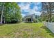 A large backyard with green grass, a white picket fence, and a screened-in porch at 3073 Penny Ln, Johns Island, SC 29455