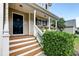 Inviting front porch with wooden steps, white railings, and hanging flower baskets providing nice curb appeal at 3073 Penny Ln, Johns Island, SC 29455