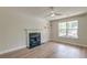 Cozy living room features wood floors, a window overlooking the backyard, and a fireplace at 3073 Penny Ln, Johns Island, SC 29455