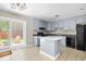 Bright kitchen features light blue cabinetry, a center island, and access to the outdoor patio at 315 Elliott Dr, Ladson, SC 29456